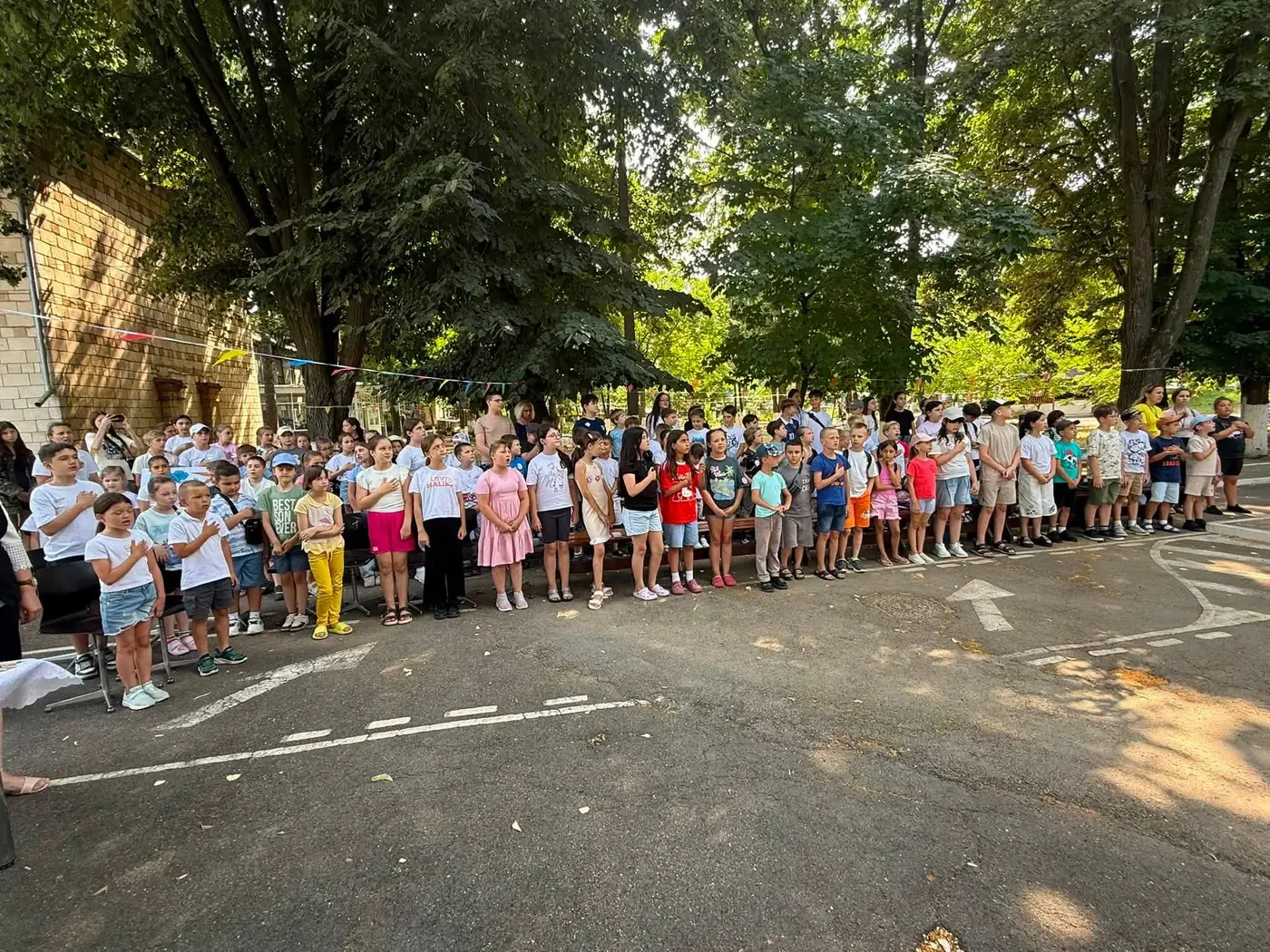 Sute de copii adunați la deschiderea unui tur al taberei de zi, în curtea unei instituții din raionul Ungheni