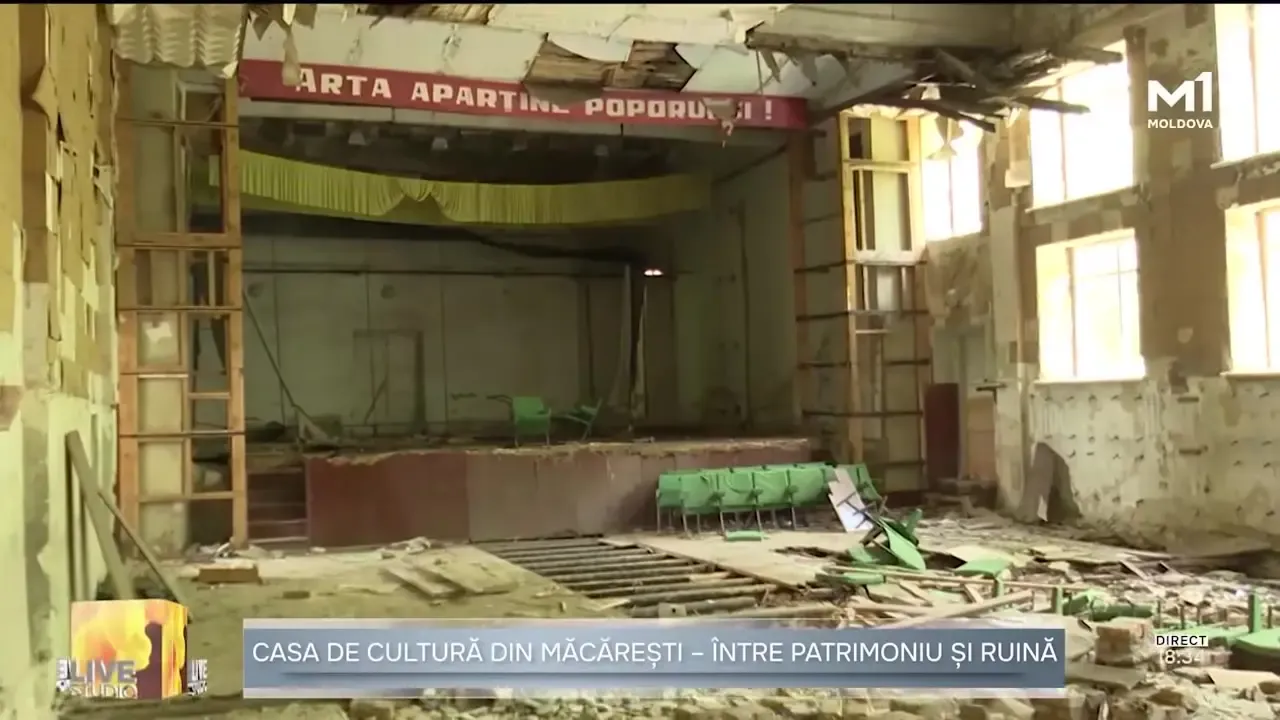 Interiorul ruinat al Casei de Cultură din Măcărești: tavan prăbușit, scaune rupte în sală, iar deasupra scenei goale a rămas lozinca «ARTA APARȚINE POPORULUI!».