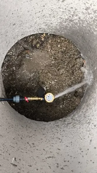 Un contor de apă nou montat, cu robinet și racord, într-un cămin de vizitare din satul Boghenii Vechi.