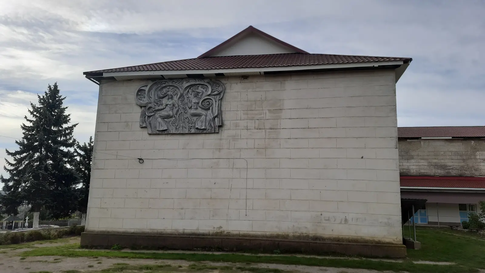 Vedere generală a unei localități rurale din raionul Ungheni, cu case, verdeață și dealuri în fundal.