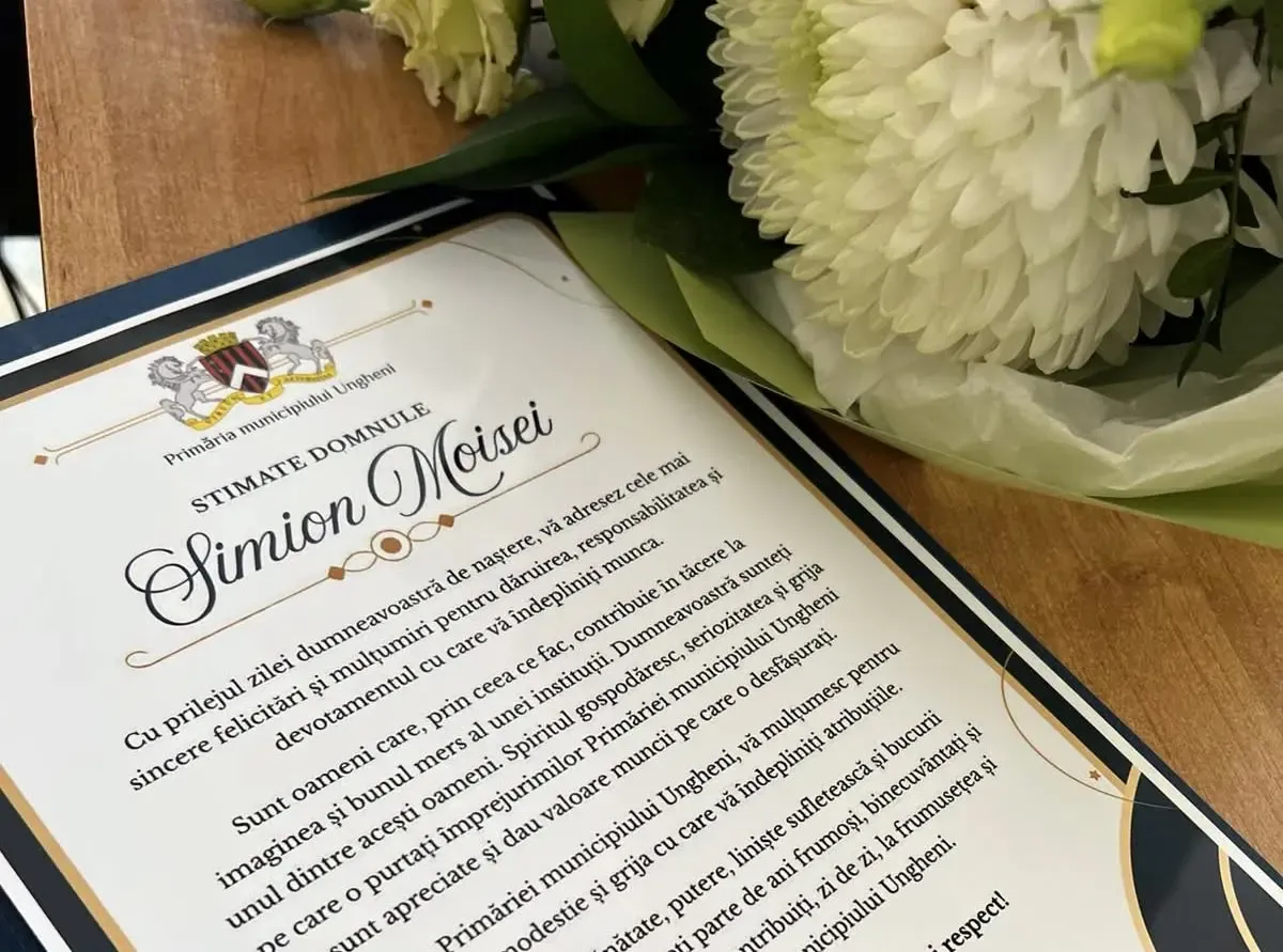 Diploma înmânată de Primăria municipiului Ungheni, pe care este scris numele „Simion Moisei”, alături de un buchet de flori albe