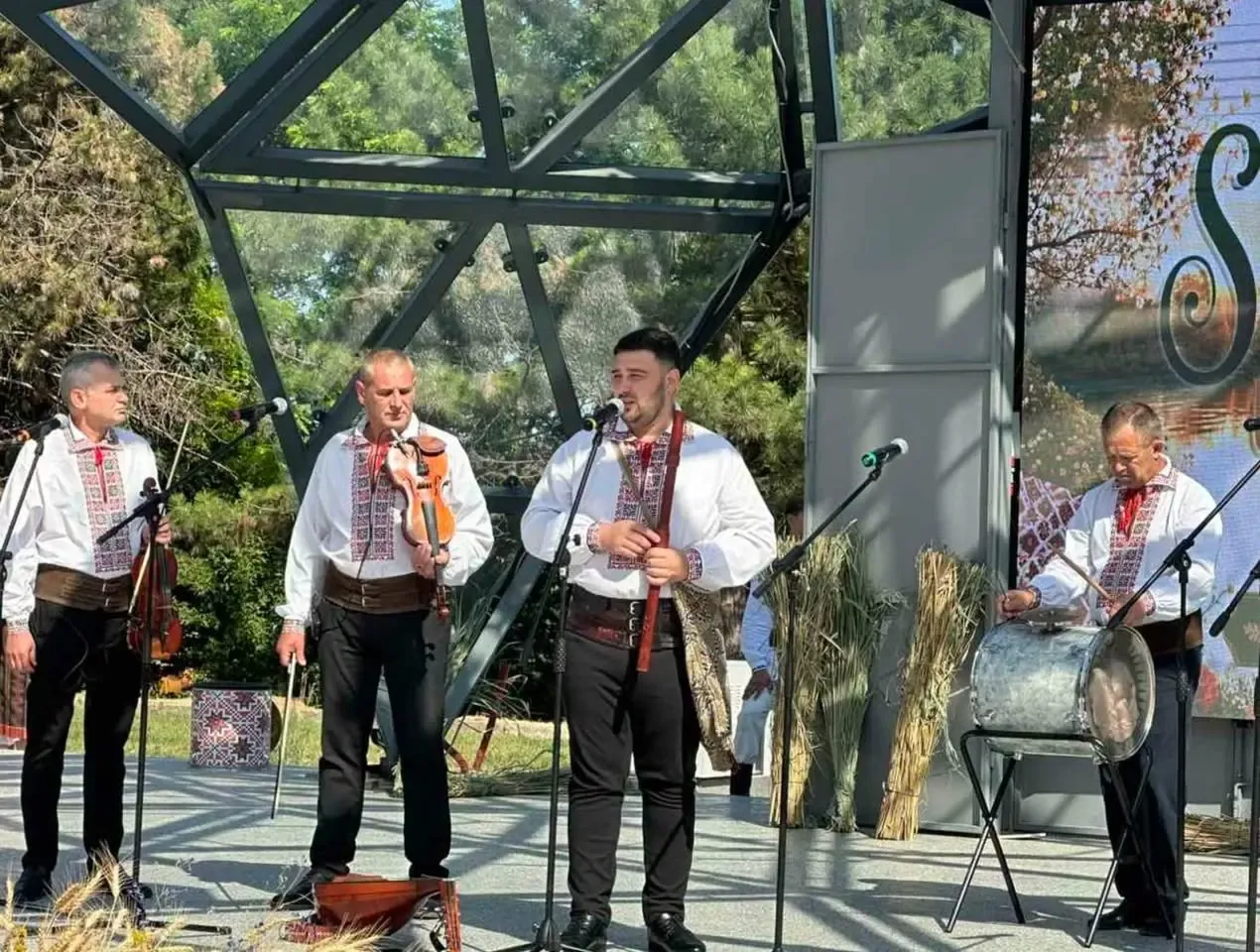 Un taraf de lăutari în cămăși tradiționale cântă pe scena festivalului din centrul Ungheniului — vioară, fluier și tobă.