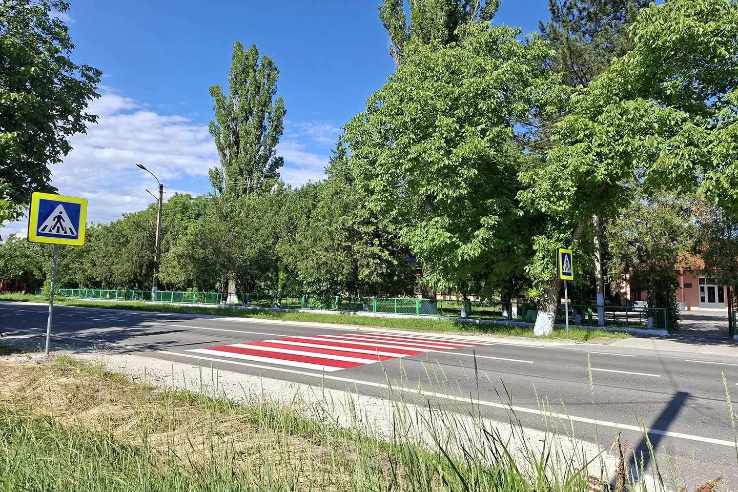 Trecere de pietoni proaspăt marcată pe R16, cu indicator de trecere, în dreptul unei instituții.